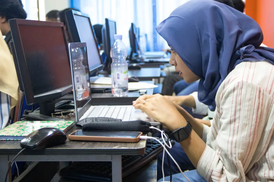Étudiante travaillant sur ordinateur en salle informatique