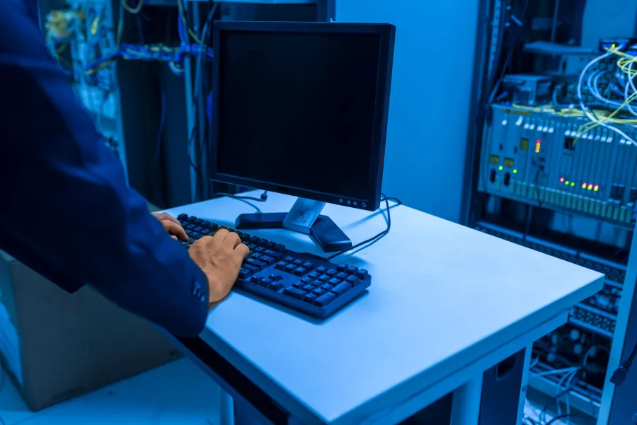 Poste de travail dans une salle serveurs, baies réseau et câblage