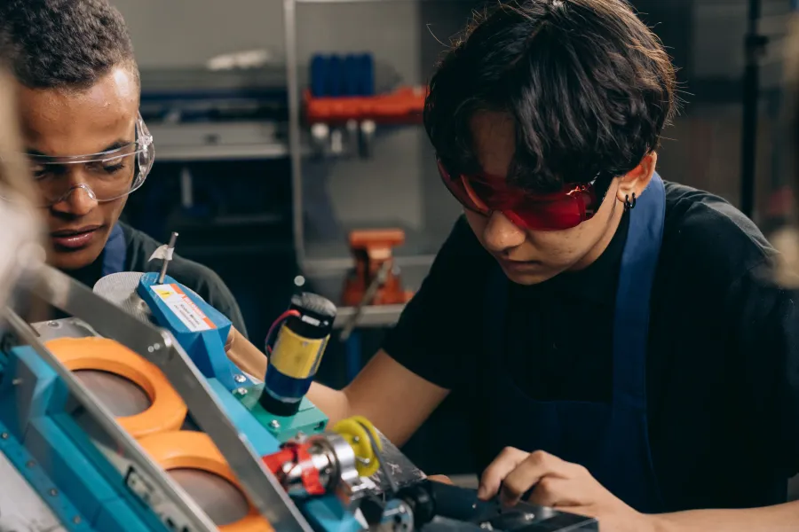 Étudiants avec lunettes de protection intervenant sur un équipement industriel