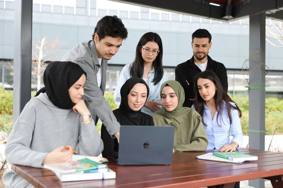 Groupe d'étudiants travaillant ensemble sur un ordinateur portable